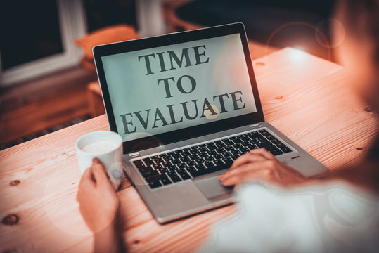 Handwriting text writing Time To Evaluate. Conceptual photo judge something with respect to its worth or significance woman laptop computer smartphone mug office supplies technological devices