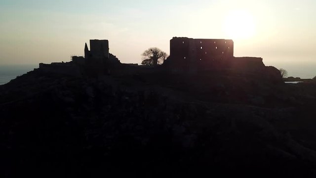 Parallax view of secluded, northern, midieval stone fortification castle at sunset