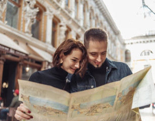 Beautiful couple on vacation using paper city map for directions. Travel vacation, leisure recreation lifestyle.