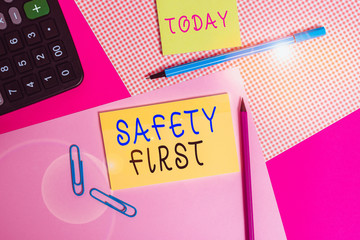 Handwriting text writing Safety First. Conceptual photo used to say that the most important thing is to be safe writing equipments with stationary and plain note paper placed on the table