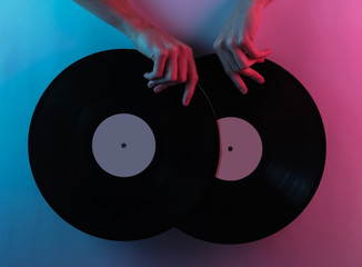 Retro wave 80s. Hands holding vinyl records. Creative pop art pink blue neon color. Trendy gradient illumination. Night light