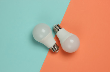 Three LED light bulbs on pink blue background. Top view