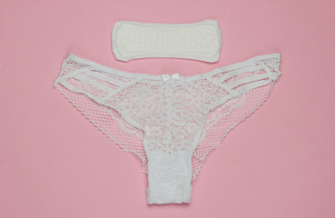 Women's panties and pad on  pink pastel background. Feminine hygiene concept. Critical days,...