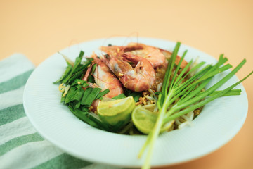 Plate of Pad Thai or Thai style fried noodle topped with prawns