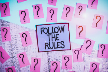 Handwriting text Follow The Rules. Conceptual photo order someone stick to certain place country guides stricts Scribbled and crumbling papers with thick cardboard above wooden table