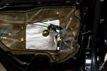 Repair of the car body black crossover in the service station, the restoration of the cabin. The side door trim panel was removed, the sound system wiring was replaced, handle and lock seeing.