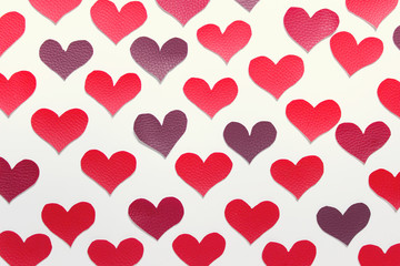 Valentine day pattern flat lay with large hand cut textured fabric hearts on white background.