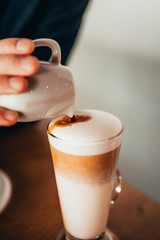 pouring espresso in hot steamed milk 