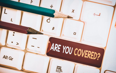 Conceptual hand writing showing Are You Covered Question. Concept meaning asking someone or patient if he have insurance White pc keyboard with note paper above the white background