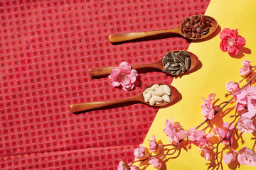 Wooden spoons with traditional snacks for Tet celebration: watermelon, sunflower and pumpkin seeds