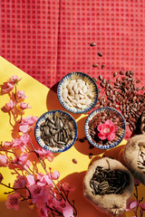 Table served for Chinese New Year celebration with bowls of seeds and blooming peach branches