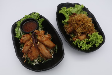 Fried chicken with sauce, herb, and vegetable in black plate