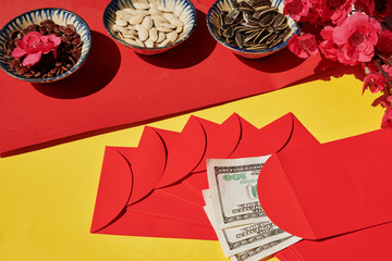 Bowls with seeds and red lucky money envelopes prepared for Chinese New Year celebration