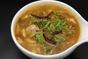 Spicy Thai herb soup with boiled chicken and mushroom
