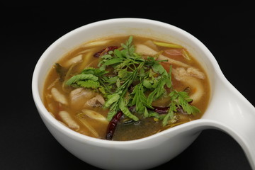 Spicy Thai herb soup with boiled chicken and mushroom