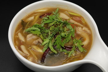 Spicy Thai herb soup with boiled chicken and mushroom