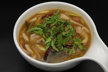 Spicy Thai herb soup with boiled chicken and mushroom