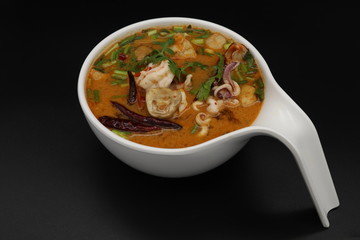 Tomyum (Thai spicy soup) with prawn and squid in herbs, mushroom and chili soup