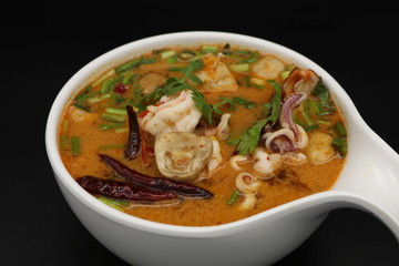 Tomyum (Thai spicy soup) with prawn and squid in herbs, mushroom and chili soup