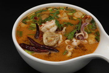Tomyum (Thai spicy soup) with prawn and squid in herbs, mushroom and chili soup