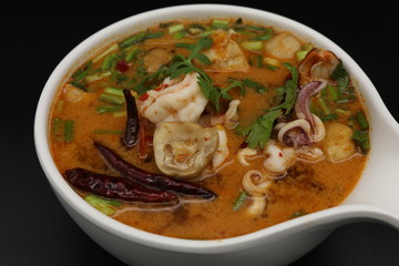 Tomyum (Thai spicy soup) with prawn and squid in herbs, mushroom and chili soup