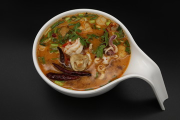 Tomyum (Thai spicy soup) with prawn and squid in herbs, mushroom and chili soup
