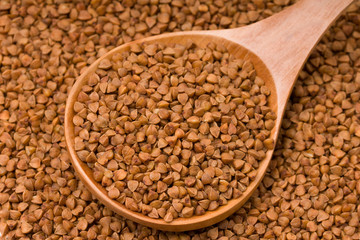  Raw buckwheat in a wooden spoon. healthy lifestyle, diet, weight loss, healthy food concept