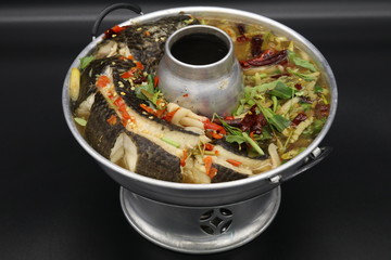 Thai soup with boiled fish with herbs and chili