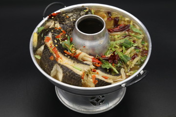 Thai soup with boiled fish with herbs and chili
