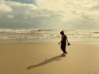 woman walking on the beach at sunset