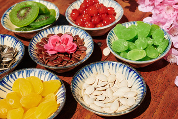 Traditional Tet snacks: dried fruits and berries and various seeds in small bowls