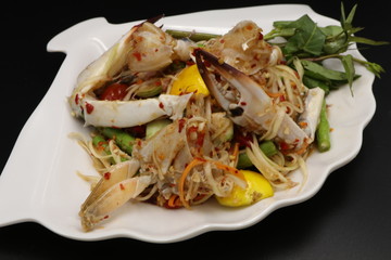 Somtum (Thai spicy salad) with raw crab in white plate