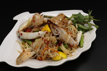 Somtum (Thai spicy salad) with raw crab in white plate