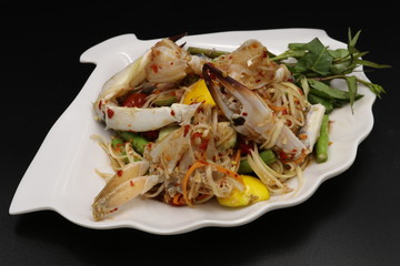 Somtum (Thai spicy salad) with raw crab in white plate