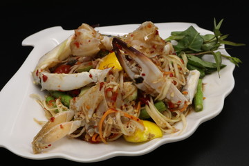 Somtum (Thai spicy salad) with raw crab in white plate