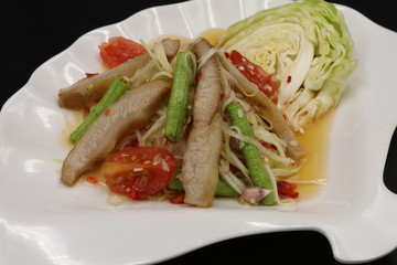 Somtum (Thai spicy salad) with grilled pork neck and vegetable in white plate