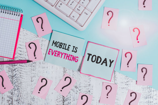 Conceptual hand writing showing Mobile Is Everything. Concept meaning Handheld Computer Device a Planner Wallet Organizer Writing tools and scribbled paper on top of the wooden table