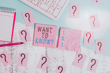 Handwriting text Want To Know Question. Conceptual photo Request for information Asking Wonder Need Knowledge Writing tools, computer stuff and math book sheet on top of wooden table