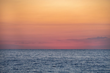 Blue sea with orange yellow sky at the dawn. Barcelona, Spain. Copy space.