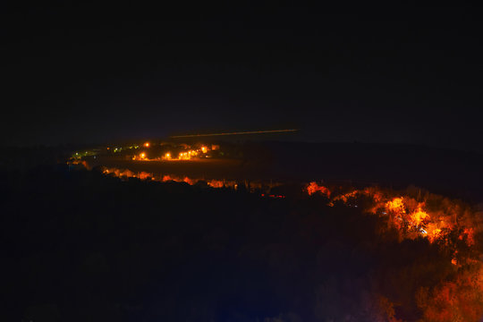 Blurred Creative Art Image Of Plane Flying Near The Ground To Land At Night. Defocused Aerial View On Night Dark Blue City