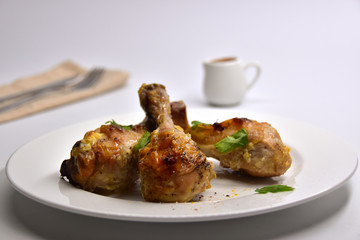 Chicken legs on a white playe on a white background.