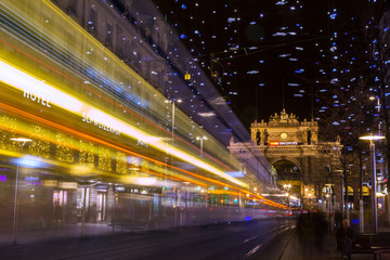 Fototapeta na wymiar Zurich, Switzerland December - 26. 2019: The Christmas illumination on the Bahnhofstrasse with a passing bus in Zurich.