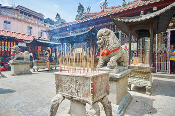 Schrein mit Räucherstäbchen und steinerner Löwe vor dem Tempel der Göttin der Gnade in...