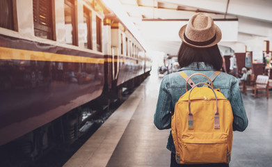 Young asian woman traveler with backpack in the railway, Backpack and hat at the train station with...