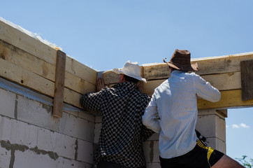guys make formwork for a reinforced belt at a construction site