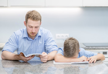 Father and his son doing homework together at home