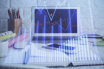 Financial chart drawing and table with computer on background. Double exposure. Concept of...