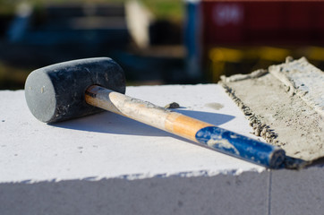 dirty mallet lies on aerated concrete brick