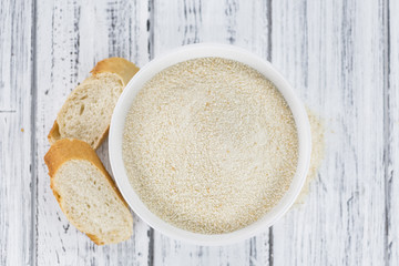 Some fresh Bread Crumbs on wooden background (selective focus; close-up shot)