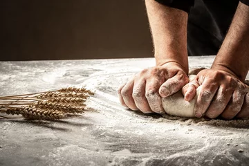 Fotobehang Hands of baker kneading dough isolated on black background. prepares ecologically natural pastries © Надія Коваль